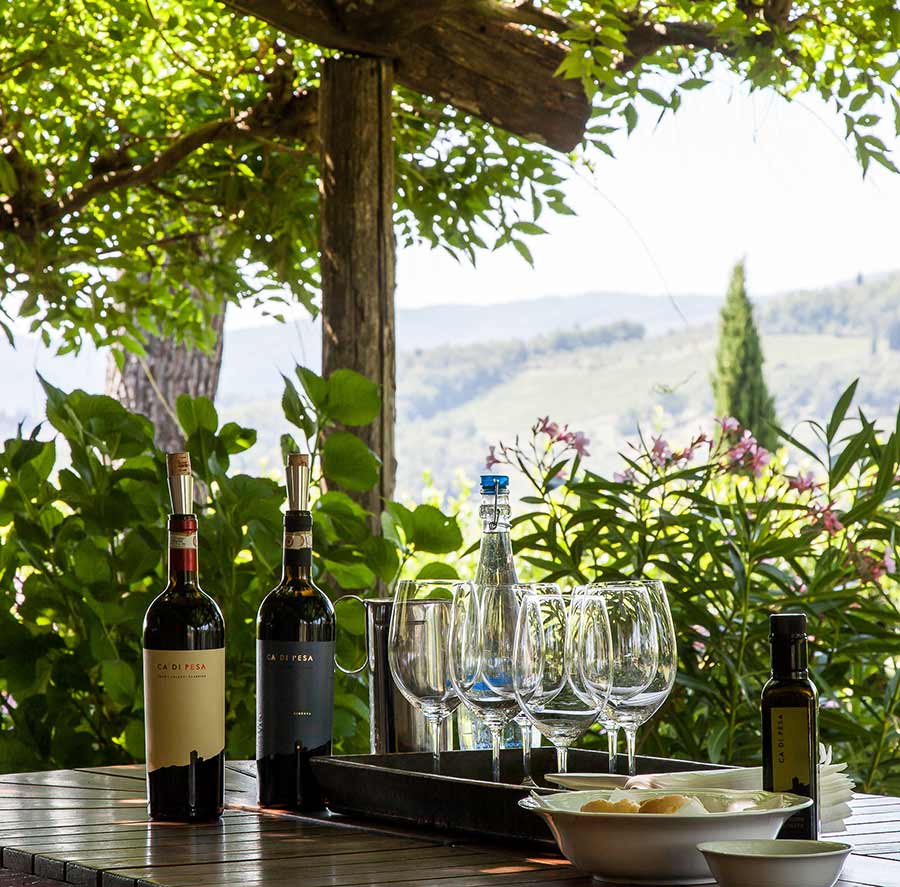 Tavolo di degustazione a Ca' di Pesa con bottiglie di Chianti Classico, calici e olio d'oliva