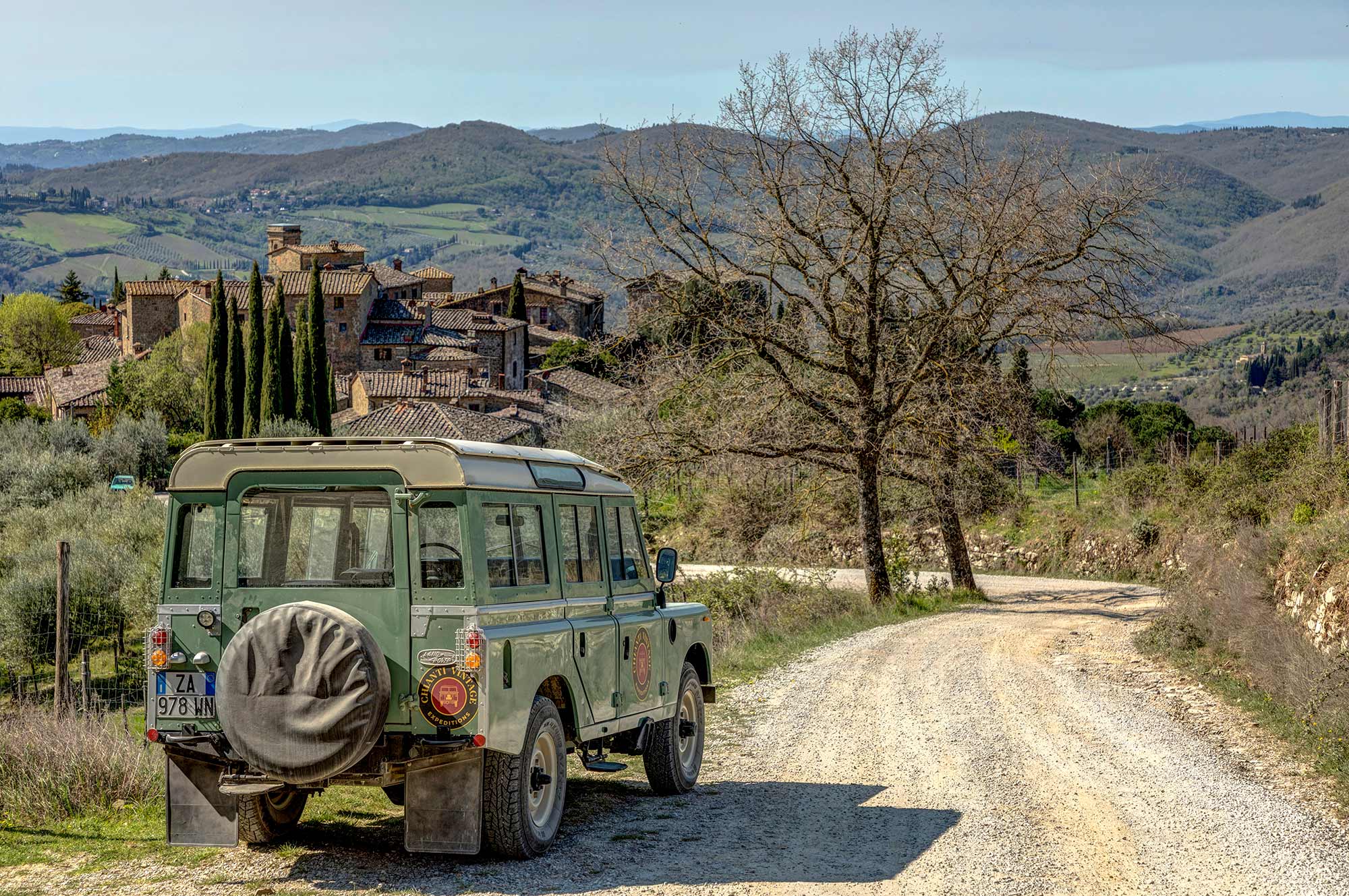 La Land Rover su una strada sterrata del Chianti con Montefioralle visibile sulla collina