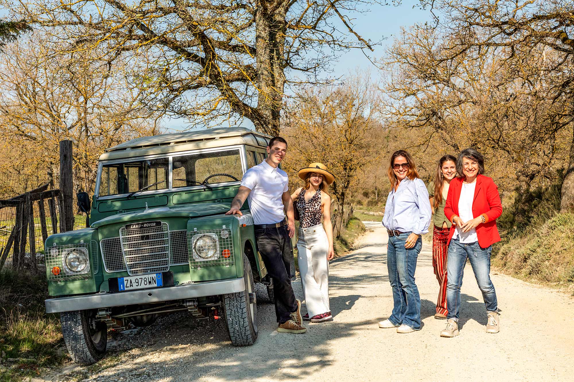 Cinque ospiti in posa con la Land Rover su una strada di campagna del Chianti