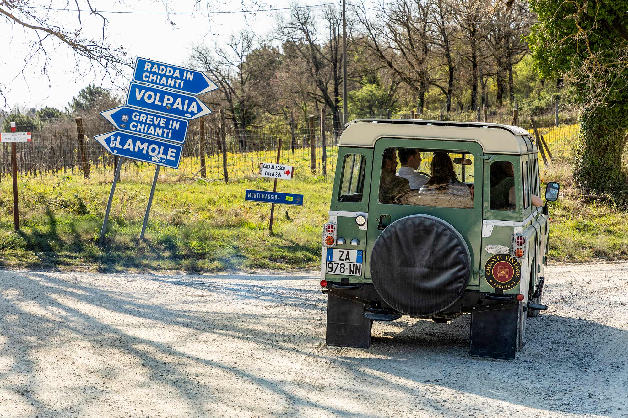 La Land Rover a un incrocio del Chianti con cartelli stradali per Volpaia, Radda e Greve