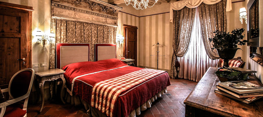 Hotel Villa Bordoni historic bedroom with terracotta floors and chandelier